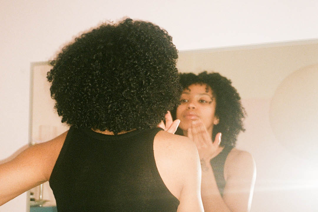 Nainen katsoo itseään peilistä